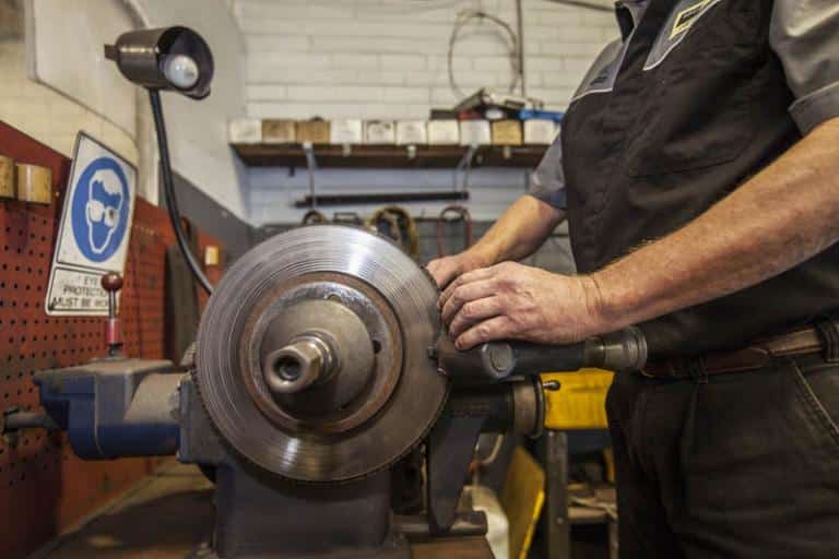 close up of an auto mechanic skimming a vehicle clutch in adrian's balcatta car centre