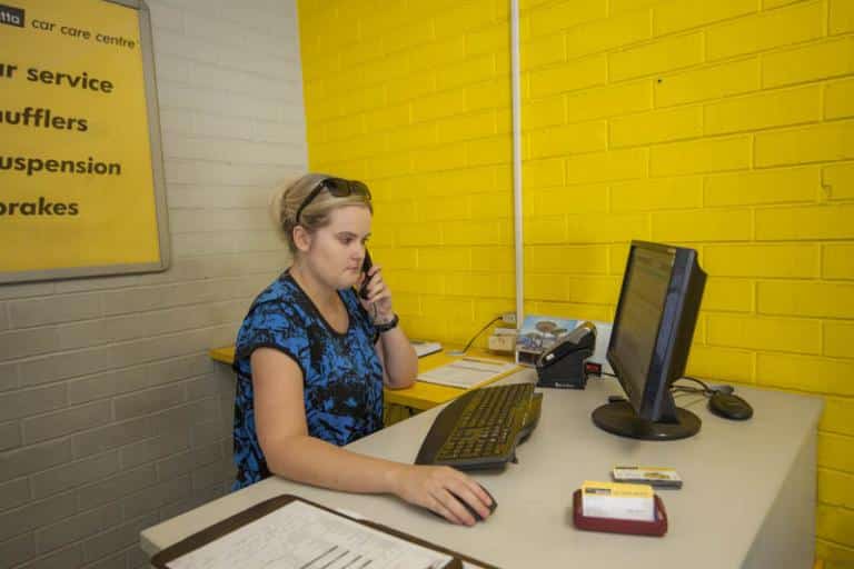 female receptionist answering phone in the reception area at adrian's balcatta car care centre